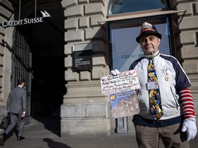 Un retraité local manifeste lundi devant le siège du Credit Suisse à Zurich après qu'UBS ait accepté de reprendre son rival suisse en difficulté.  Les actions des banques européennes ont chuté malgré le sauvetage visant à prévenir une crise bancaire mondiale.