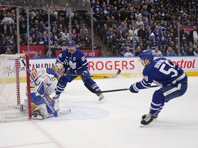 Le gardien de but des Sabres de Buffalo Craig Anderson (41) et l'attaquant des Maple Leafs de Toronto John Tavares (91) regardent un tir de l'attaquant Michael Bunting (58) s'écarter du filet au cours de la troisième période au Scotiabank Arena le 13 mars 2023.