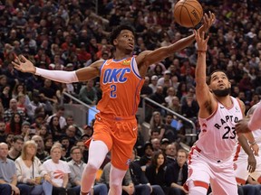 Le garde du Thunder d'Oklahoma City, Shai Gilgeous-Alexander, à gauche, et le garde des Raptors de Toronto, Fred VanVleet, se battent pour un ballon perdu en première mi-temps à la Scotiabank Arena, le 29 décembre 2019.