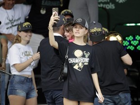 Mallory Edens, fille du copropriétaire des Milwaukee Bucks Wes Edens, prend une photo lors d'un défilé célébrant l'équipe de basket-ball du championnat NBA des Milwaukee Bucks le jeudi 22 juillet 2021 à Milwaukee.  (AP Photo/Aaron Gash)