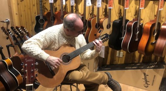 Tarn Adams playing a guitar