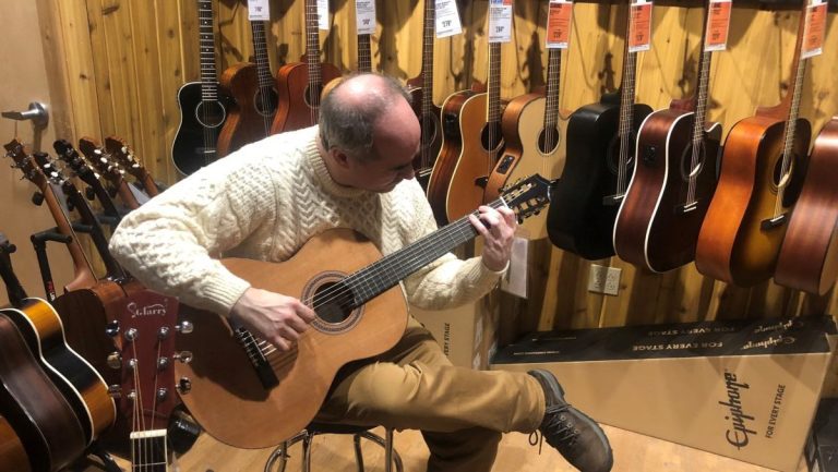 Tarn Adams playing a guitar