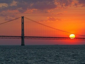 Dans cette photo d'archives du 31 mai 2002, le soleil se couche sur le pont Mackinac et le détroit de Mackinac vus du lac Huron.