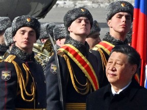 Le président chinois Xi Jinping passe devant des gardes d'honneur lors d'une cérémonie d'accueil à l'aéroport de Vnoukovo à Moscou le 20 mars 2023.