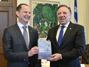 Le ministre des Finances du Québec, Éric Girard, à gauche, et le premier ministre du Québec, François Legault, tiennent une copie du discours du budget, au bureau du premier ministre à Québec.