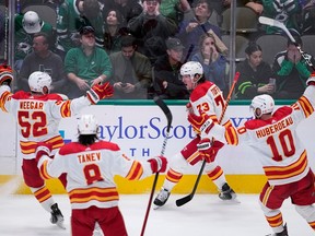 L'attaquant des Flames de Calgary Tyler Toffoli célèbre avec MacKenzie Weegar, Chris Tanev et Jonathan Huberdeau après avoir marqué le but gagnant contre les Stars de Dallas dans les dernières secondes de la troisième période au American Airlines Center de Dallas le lundi 6 mars 2023.