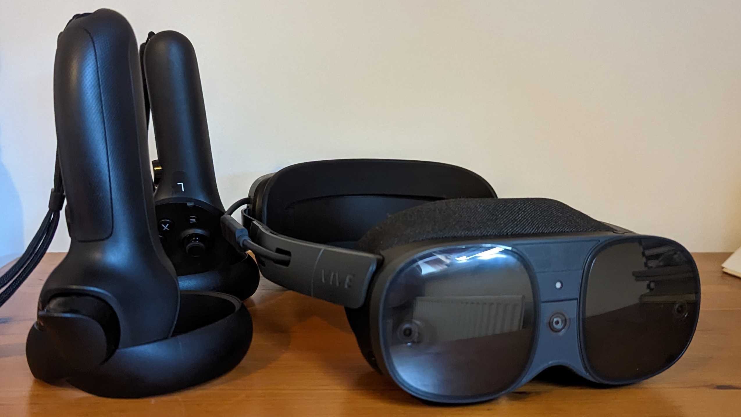 Le Vive XR Elite et ses manettes sur une table en bois