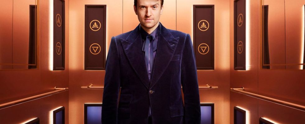 Greg James stands in the elevator of Rise and Fall