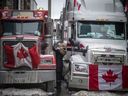 Une femme accueille un chauffeur de camion pendant que des véhicules bordent les rues du centre-ville pendant la 