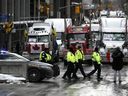 Des policiers patrouillent à pied le long de la rue Albert pour protester contre les restrictions liées à la COVID-19 qui ont été marquées par des embouteillages et le son des klaxons des camions a atteint son 14e jour à Ottawa, le 10 février 2022.