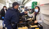 Le client de la banque alimentaire de Fort York, Vernon Harris, s'entretient avec le bénévole Xin Yue au 380 College St. à Toronto le mercredi 5 avril 2023. 