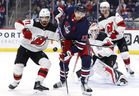 Le défenseur des Devils du New Jersey Jonas Siegenthaler (à gauche) et le centre des Jets de Winnipeg Adam Lowry (17 ans) regardent une rondelle volante en deuxième période au Canada Life Centre dimanche soir.  James Carey Lauder/USA AUJOURD'HUI Sports