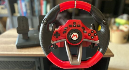 Hori Mario Kart Racing Wheel Pro Deluxe racing wheel attached to a wooden table