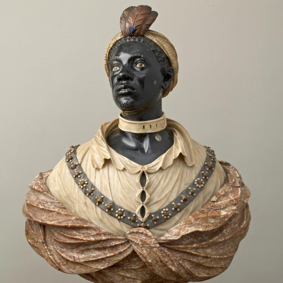 Un buste en marbre coloré d'un homme à la peau foncée, la tête tournée et regardant vers la gauche ;  coiffé d'un turban à plumes, col autour du cou, chemise à col orné de bijoux et châle noué autour ;  reposant sur un socle en marbre tourné cintré.  - La Collection Royale