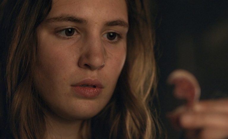 Close up on a teen girl closely examining a severed human ear; still from "Yellowjackets"