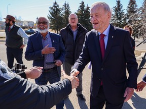 Jean Chrétien serre la main des médias et d'autres passants devant le bureau de circonscription du député George Chahal jeudi.