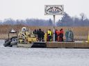 Des chercheurs accostent dans une marina à Akwesasne, au Québec.  Vendredi 31 mars 2023. Les recherches se poursuivent pour retrouver un homme porté disparu de la communauté mohawk d'Akwesasne dans un secteur du fleuve Saint-Laurent où les corps de huit migrants ont été retrouvés plus tôt cette semaine.