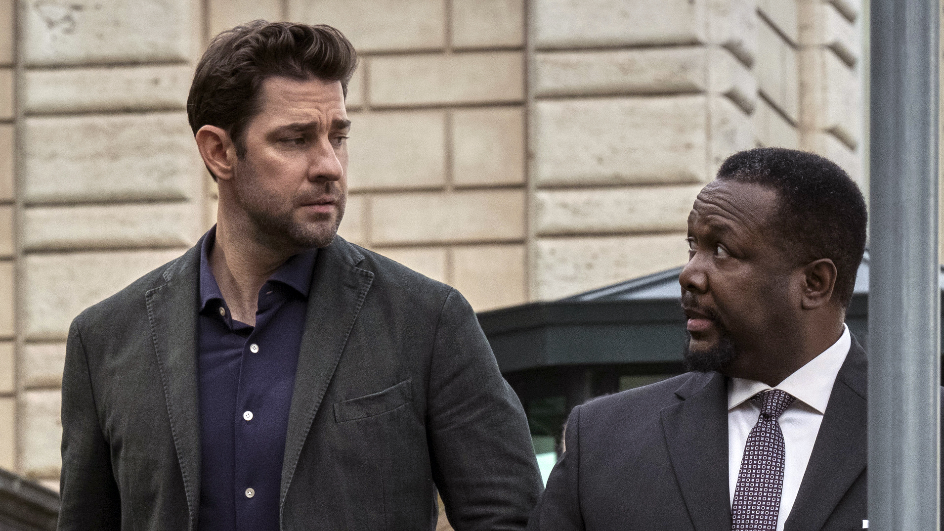 (De gauche à droite) John Krasinski (comme Jack Ryan) et Wendell Pierce (comme James Greer) se regardent dans la rue dans Jack Ryan saison 3