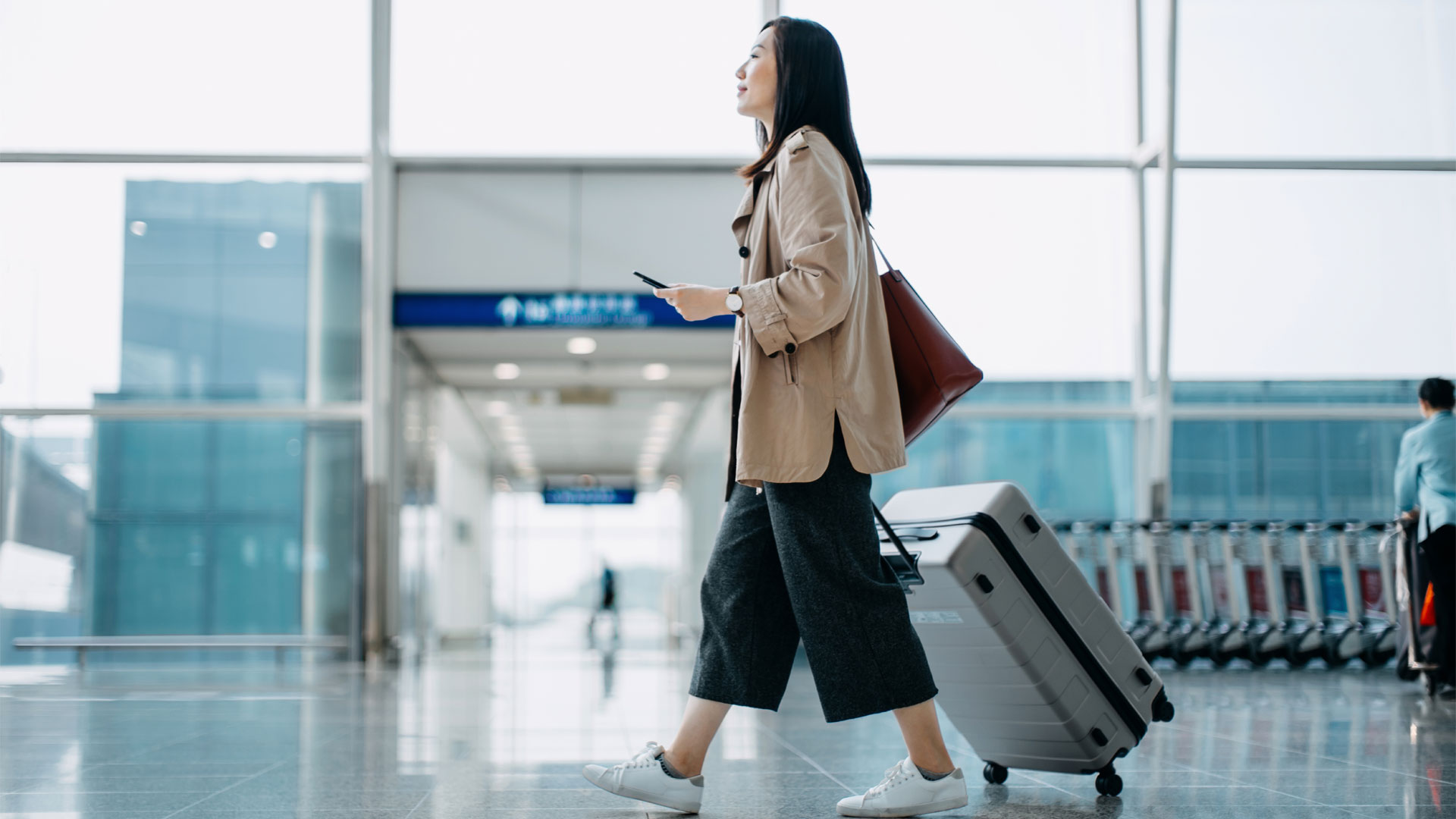 Une femme traînant sa valise dans un aéroport