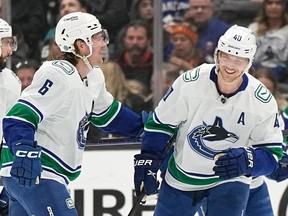 Le centre des Canucks de Vancouver Elias Pettersson, à droite, célèbre son 100e point Brock Boeser lors de la première période contre les Ducks d'Anaheim le mardi 11 avril 2023, à Anaheim, en Californie.