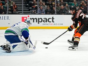 Le centre des Ducks d'Anaheim Isac Lundestrom, à droite, tente de marquer sur le gardien de but des Canucks de Vancouver Thatcher Demko lors de la première période, le mardi 11 avril 2023, à Anaheim, en Californie.