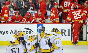 Un banc abattu des Flames de Calgary regarde les Predators de Nashville célébrer leur victoire en fusillade lundi soir.