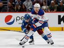 Le centre des Oilers d'Edmonton Connor McDavid (97) contrôle la rondelle sous la pression du centre de l'Avalanche du Colorado Evan Rodrigues (9) en première période au Ball Arena le mardi 11 avril 2023.