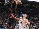 L'attaquant des Raptors de Toronto Chris Boucher (25) dunks contre le centre des Denver Nuggets Nikola Jokic (15) au cours de la première mi-temps à la Scotiabank Arena mardi soir.