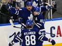 L'attaquant des Maple Leafs de Toronto Mitchell Marner et l'attaquant William Nylander félicitent l'attaquant Auston Matthews pour son but contre le Lightning de Tampa Bay lors de la deuxième période du premier match de la première ronde des séries éliminatoires de la Coupe Stanley 2022 à la Scotiabank Arena. 