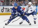 L'attaquant du Lightning Anthony Cirelli, à droite, patine pour contenir l'attaquant des Maple Leafs William Nylander, à gauche, lors de la première période d'action de la LNH au Scotiabank Arena de Toronto, le 20 décembre 2022.