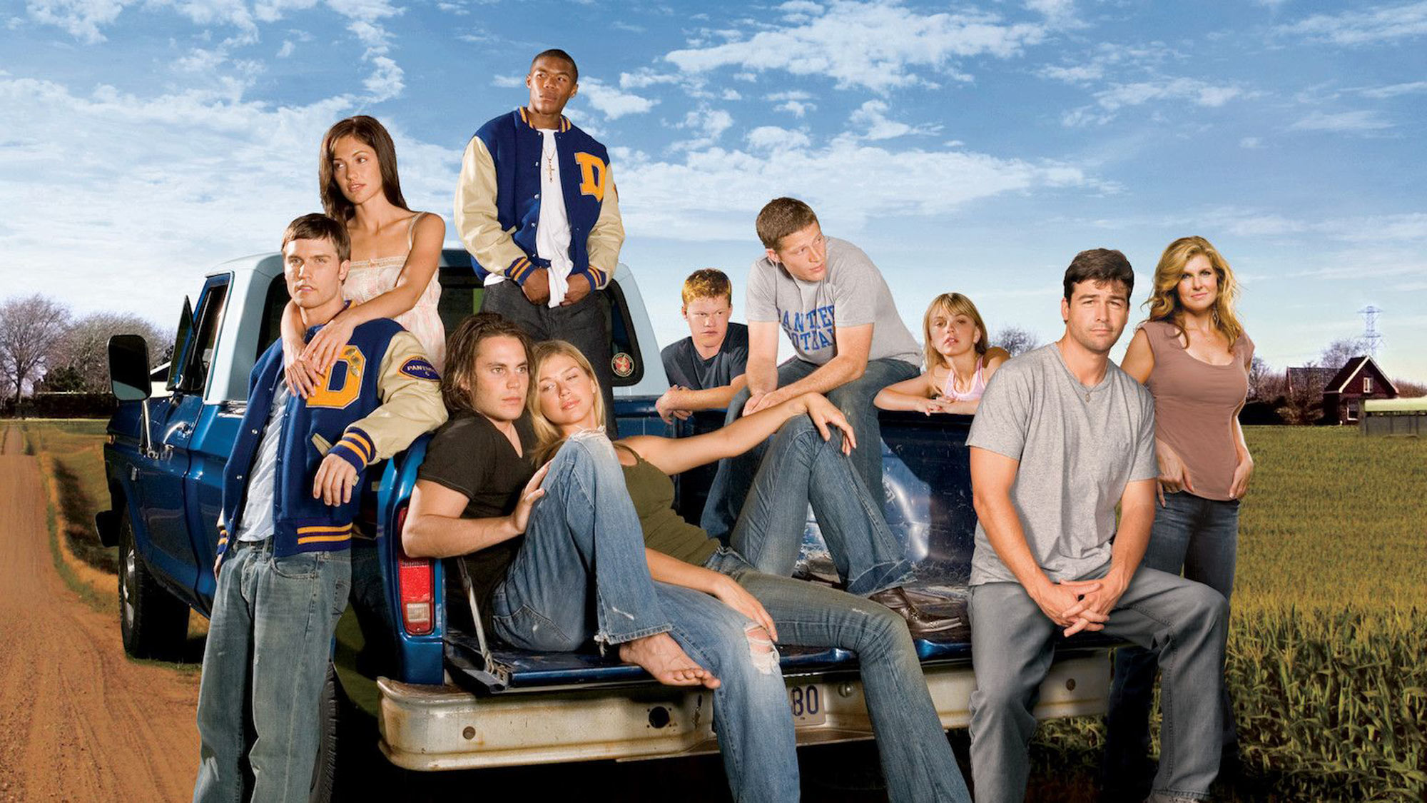 Le casting de Friday Night Lights debout dans et autour d'une camionnette sur une route