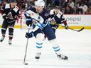 Le centre des Jets de Winnipeg Adam Lowry (17 ans) contrôle la rondelle en troisième période contre l'Avalanche du Colorado au Ball Arena.