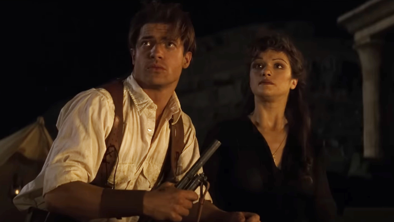 Brendan Fraser et Rachel Weisz regardent d'un air sinistre le ciel nocturne dans La Momie.