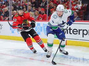 Brock Boeser contrôle la rondelle contre Nikita Zaitsev des Blackhawks de Chicago lors de la première période au United Center le 26 mars 2023 à Chicago, Illinois.