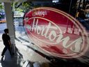 Un piéton passe devant un restaurant Tim Hortons au centre-ville de Vancouver.