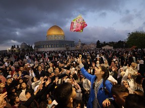 Vendredi a marqué le premier jour de l'Aïd al-Fitr et la fin du mois de jeûne du Ramadan.  Des centaines de milliers de personnes devaient visiter la mosquée Al-Aqsa à Jérusalem pour marquer le jour saint.  Sur cette photo, une fille attrape un cadeau flottant dans les airs à l'extérieur du Dôme du Rocher.  Ahmad Gharabli/AFP