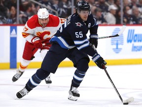 Mark Scheifele # 55 des Jets de Winnipeg déplace la rondelle devant Milan Lucic # 17 des Flames de Calgary.  Les Jets ont besoin que Scheifele soit à son meilleur pour dépasser Vegas.