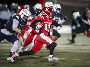 Les Red Leafs de l'Université Simon Fraser, Robert Meadors, dirigent le ballon sur le terrain tout en essayant d'éviter d'être plaqués par Luke Burton-Krahn des rivaux de la ville, les Thunderbirds de l'UBC, lors du 34e Shrum Bowl à SFU le vendredi 2 décembre 2022.