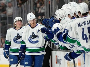 Le centre des Canucks de Vancouver Elias Pettersson, deuxième à partir de la gauche, célèbre son 100e point avec ses coéquipiers sur le banc alors qu'il est suivi par l'ailier droit Brock Boeser lors de la première période contre les Ducks d'Anaheim le mardi 11 avril 2023 à Anaheim, en Californie.