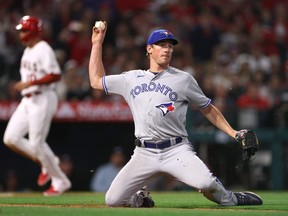 Chris Bassitt des Blue Jays de Toronto fait un lancer au premier sur une carie de David Fletcher des Angels de Los Angeles alors que Gio Urshela marque, pour prendre une avance de 3-1 des Angels, lors de la quatrième manche du match d'ouverture à domicile de 2023 au Angel Stadium d'Anaheim le 7 avril 2023 à Anaheim, Californie.