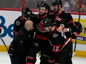 Les coéquipiers des Sénateurs Shane Pinto, Alex DeBrincat et Austin Watson aident Derick Brassard à sortir de la glace après qu'il s'est blessé au cours de la deuxième période du match à domicile de jeudi contre les Flyers.