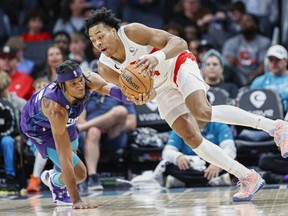 Scottie Barnes des Raptors, (à droite) bat l'attaquant des Charlotte Hornets Xavier Sneed pour une balle lâche au cours de la seconde mi-temps à Charlotte, en Caroline du Nord, le dimanche 2 avril 2023. Toronto a gagné 128-108.