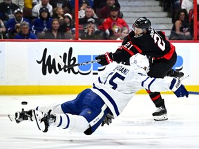 L'ailier des Sénateurs Mathieu Joseph (21 ans) décoche un tir alors que le défenseur des Maple Leafs Mark Giordano plonge dans le but de le bloquer en deuxième période.