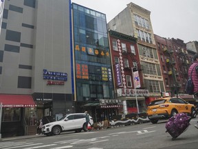 Un bâtiment de six étages à la façade en verre, le deuxième à partir de la gauche, serait le site d'un avant-poste de la police étrangère pour la Chine dans le quartier chinois de New York, le lundi 17 avril 2023.