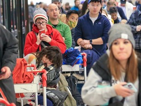 Des centaines de passagers WestJet font la queue en attendant de réserver des vols annulés à l'aéroport international de Calgary le 20 décembre 2022. Des problèmes météorologiques partout au Canada ont causé des retards et des annulations de vols.