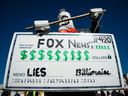 Un personnage tient un chèque symbolique lors d'une manifestation de la gare Union aux bureaux de Fox News, le 4 novembre 2020 à Washington, DC 