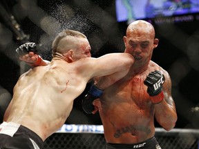 Rory MacDonald, à gauche, et Robbie Lawler échangent des coups lors de leur combat d'arts martiaux mixtes pour le titre des poids mi-moyens à l'UFC 189 à Las Vegas, le samedi 11 juillet 2015. MacDonald se dirige maintenant vers le Temple de la renommée de l'UFC.