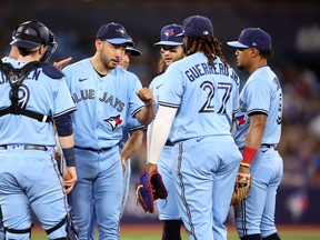 Yusei Kikuchi des Blue Jays de Toronto frappe du poing ses coéquipiers alors qu'il quitte le match contre les White Sox de Chicago.