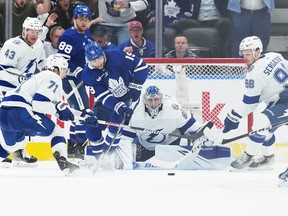 Le centre des Maple Leafs de Toronto Calle Jarnkrok (19) se bat pour la rondelle avec le centre du Lightning de Tampa Bay Anthony Cirelli (71) devant le gardien de but Andrei Vasilevskiy (88) au cours de la deuxième période du match 5 du premier tour des séries éliminatoires de la Coupe Stanley 2023 à Scotiabank Arena à Toronto, le 27 avril 2023.