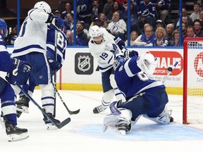 24 avril 2023 ;  Tampa, Floride, États-Unis ;  Le défenseur des Maple Leafs de Toronto Morgan Rielly et le centre John Tavares défendent l'aile gauche du Lightning de Tampa Bay Brandon Hagel pendant la première période du quatrième match du premier tour des séries éliminatoires de la Coupe Stanley 2023 à l'Amalie Arena.